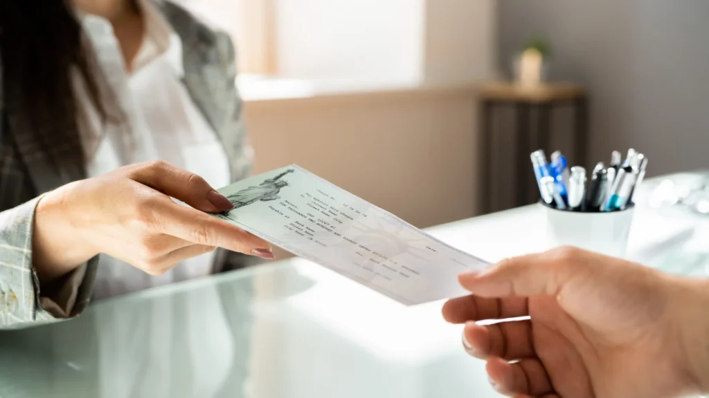 a cruise ship injury lawyer handing over a settlement check to a cruise ship injury victim