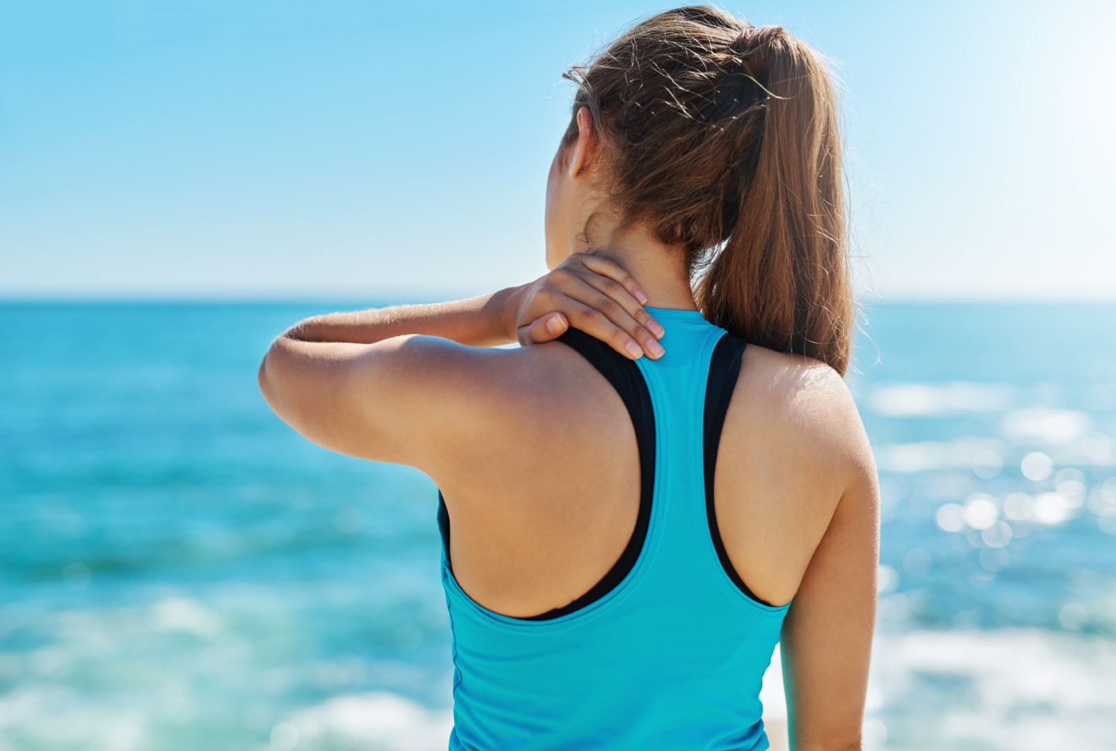 A woman overlooking the ocean with a back injury