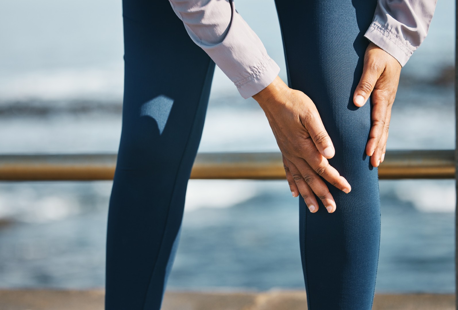A woman on a cruise ship holding her knee in pain